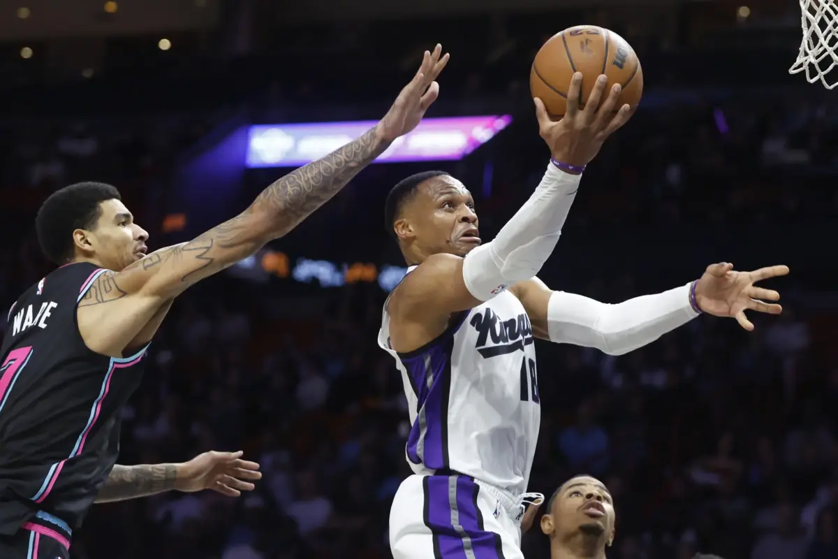 Dec 6, 2025; Miami, Florida, USA; Sacramento Kings guard Russell Westbrook (18) shoots around Miami Heat center Kel'el Ware (7) during the second half at Kaseya Center. Mandatory Credit: Rhona Wise-Imagn Images