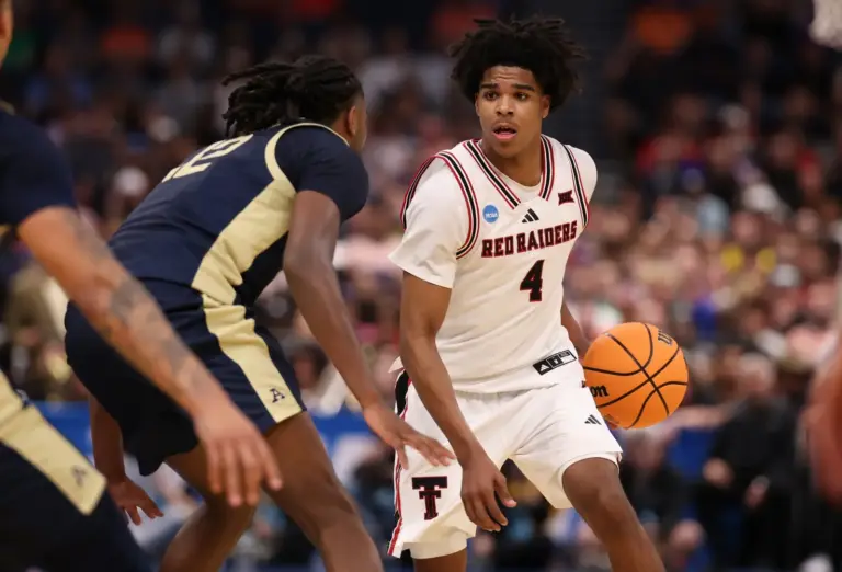Texas Tech Red Raiders guard Christian Anderson (4) dribbles against Akron Zips guard Evan Mahaffey (12) in the first half during a first round game of the men's 2026 NCAA Tournament at Benchmark International Arena.