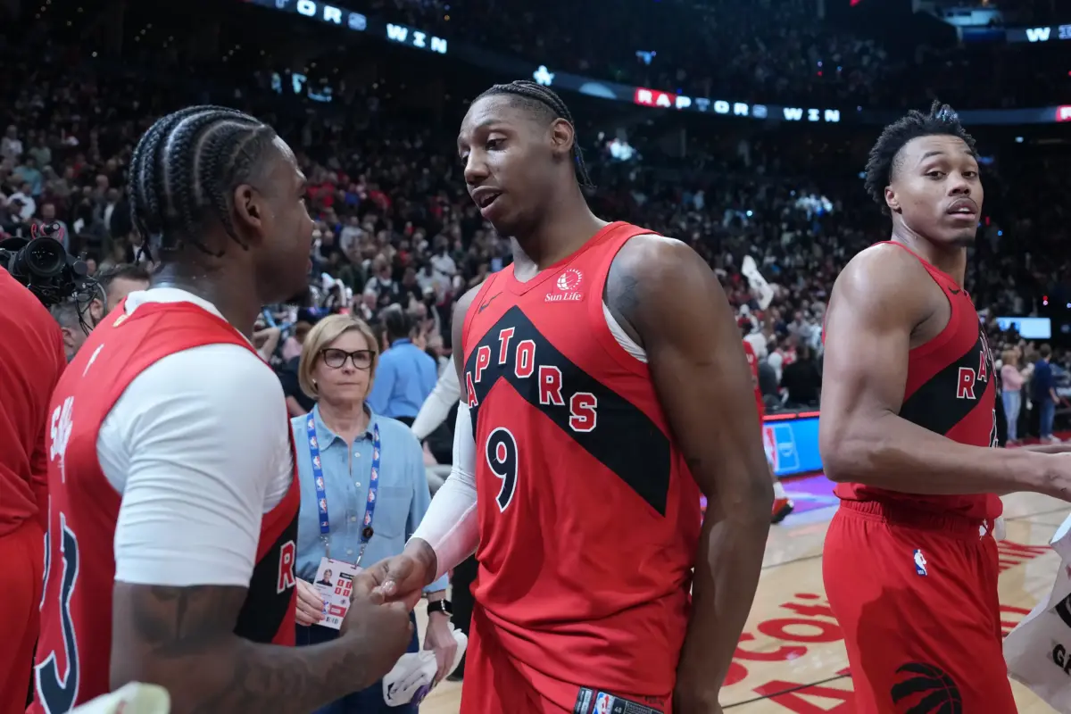 Toronto Raptors wing RJ Barrett shakes hands with teammate Jamal Shead after game-winner as Scottie Barnes looks on