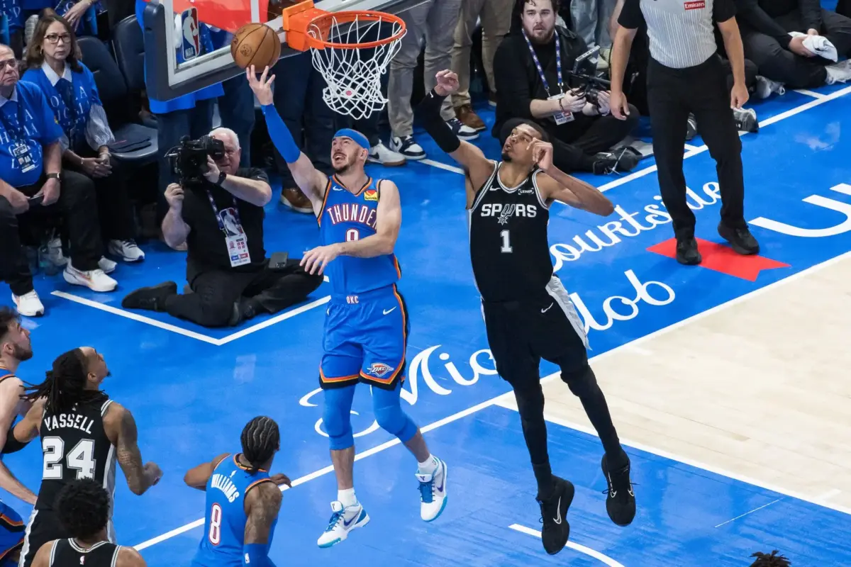 Oklahoma City Thunder guard Alex Caruso (9) shoots while defended by San Antonio Spurs center Victor Wembanyama (1) in double overtime during game one of the western conference finals for the 2026 NBA playoffs at Paycom Center.