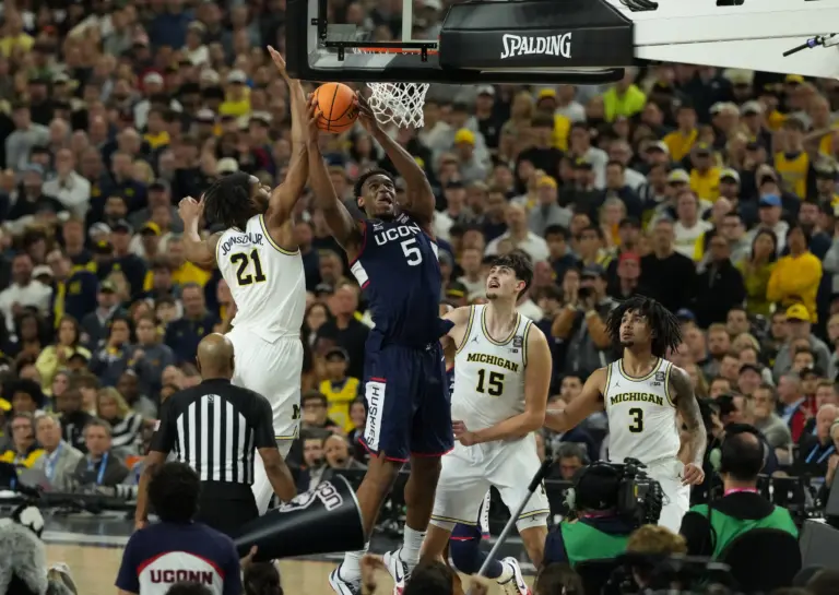 Michigan Wolverines forward Morez Johnson Jr. (21) defends against Connecticut Huskies forward Tarris Reed Jr. (5) in the second half during the national championship of the Final Four of the men's 2026 NCAA Tournament at Lucas Oil Stadium.