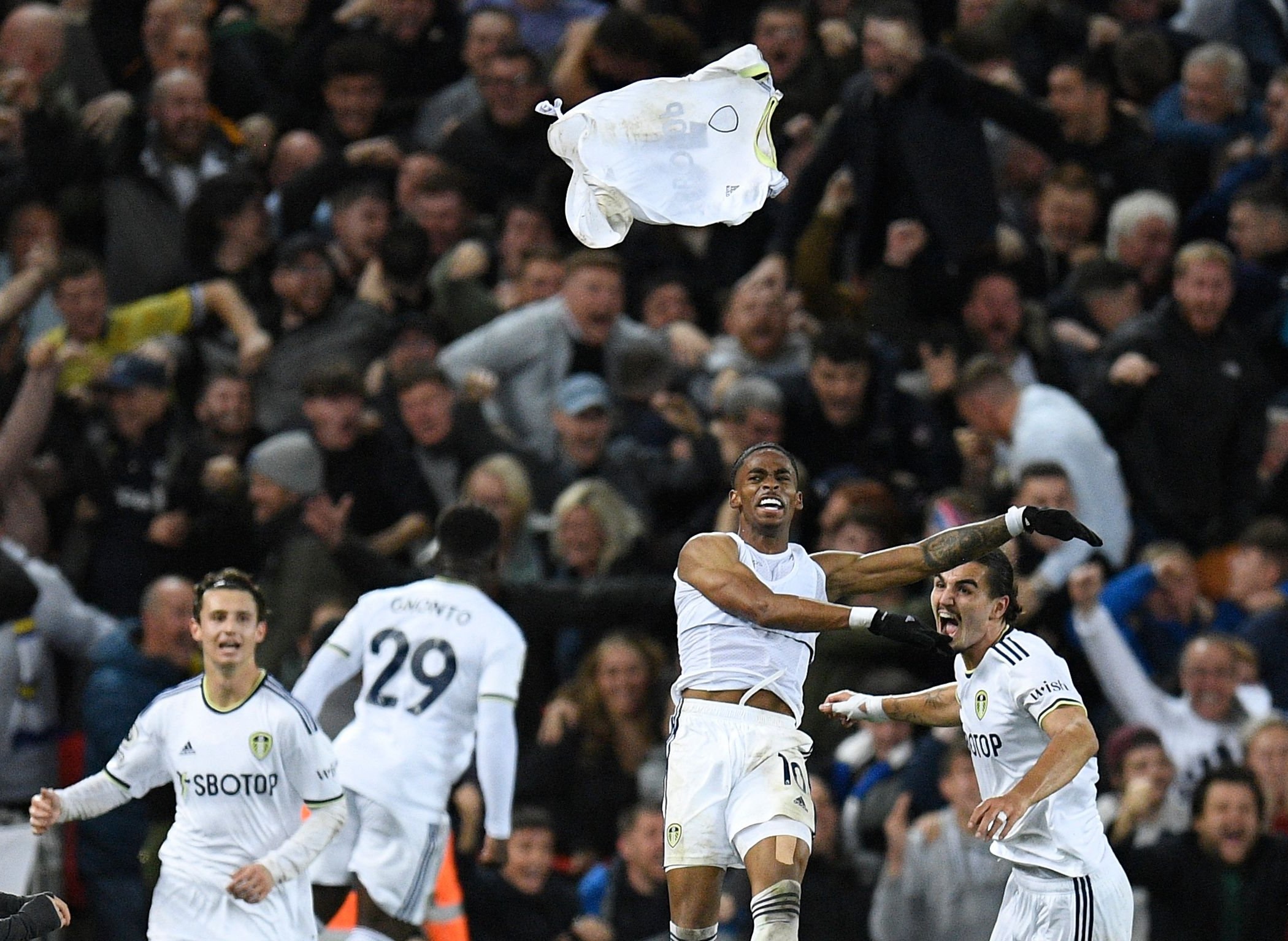 Leeds United player Crysencio Summerville celebrating by throwing his shirt.