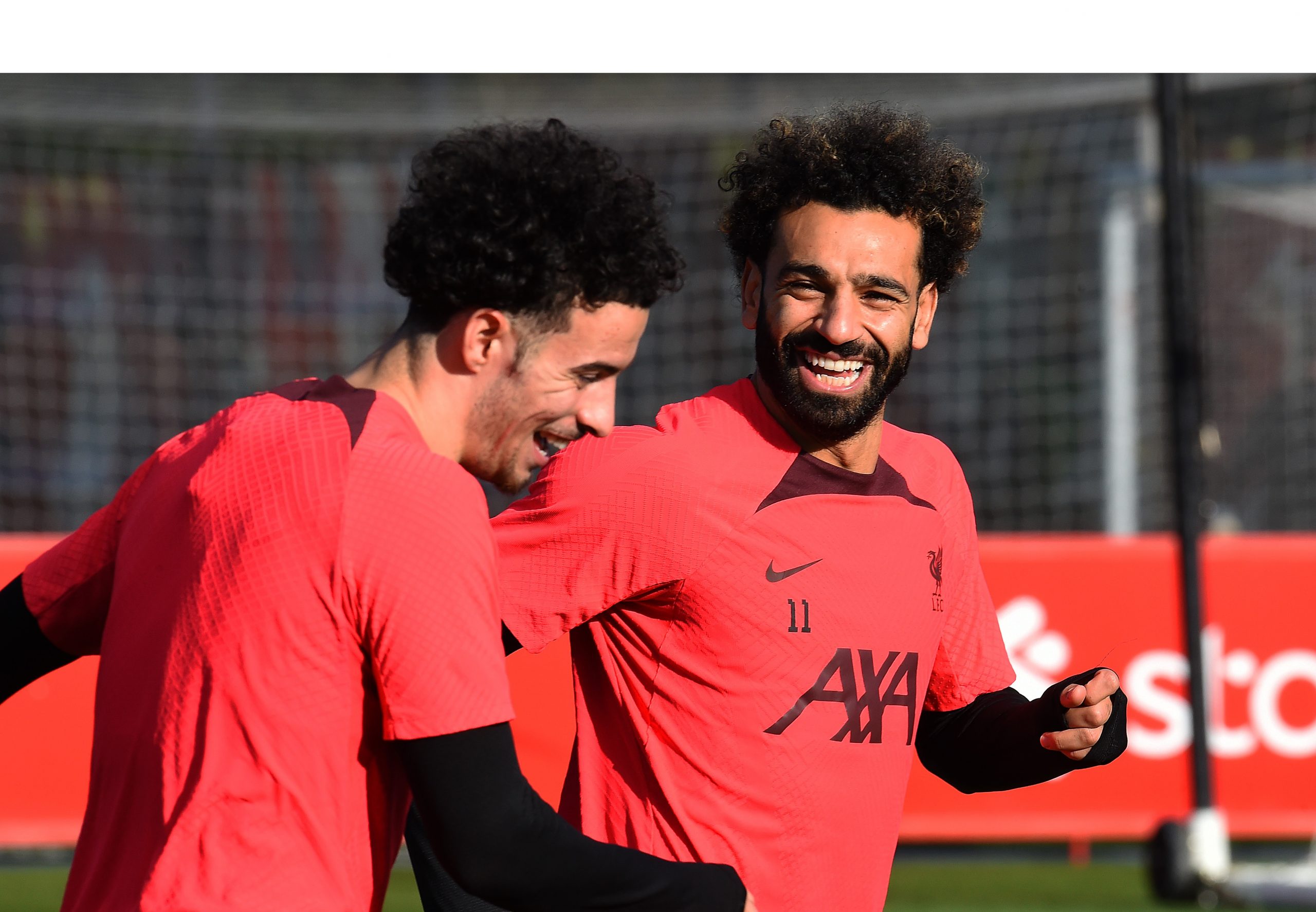 Mo Salah smiling with a teammate in training