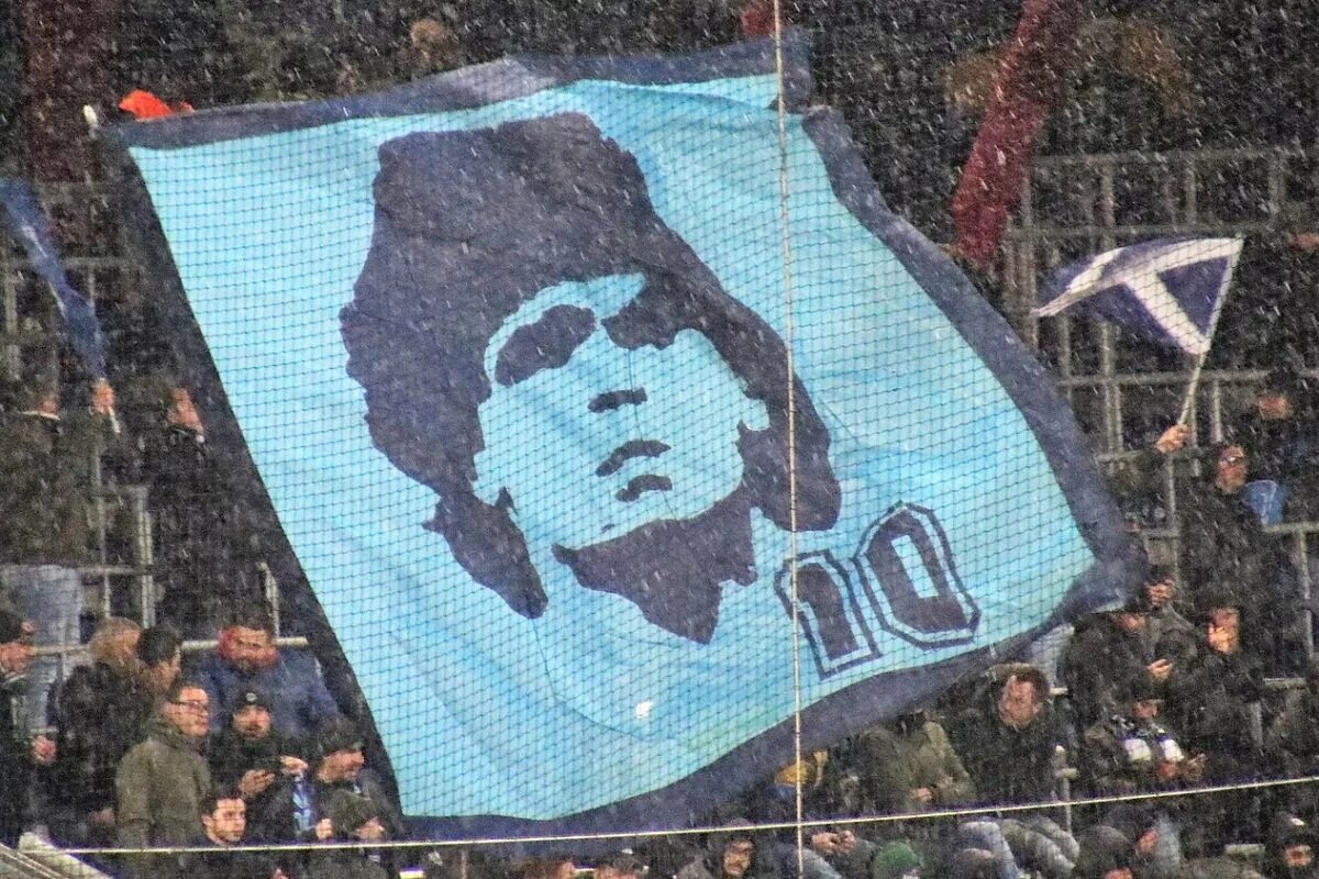 Napoli fans hoisting up a banner of Diego Maradona during a match