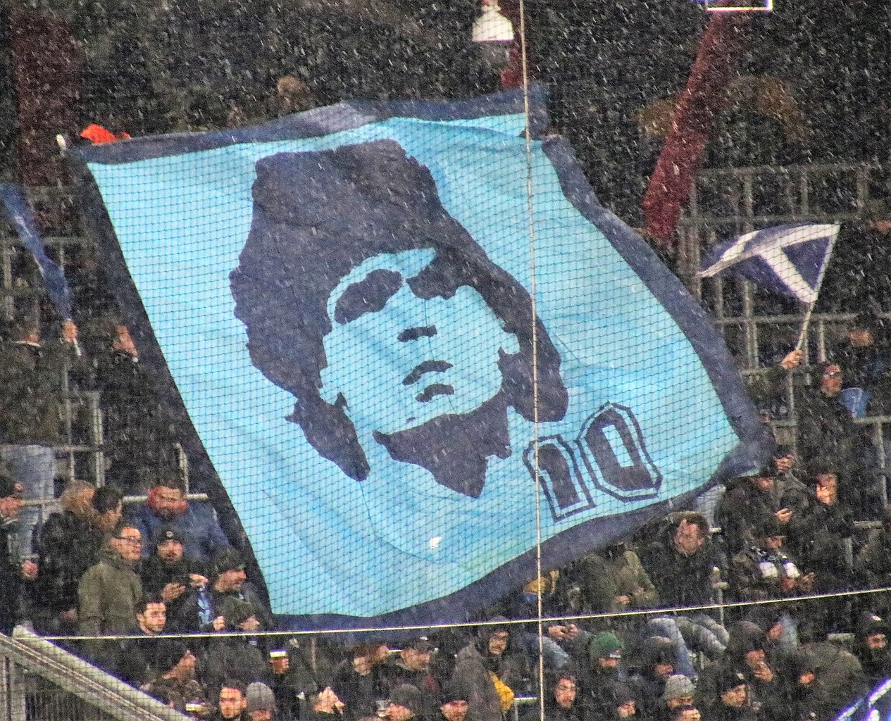 Napoli fans hoisting up a banner of Diego Maradona during a match