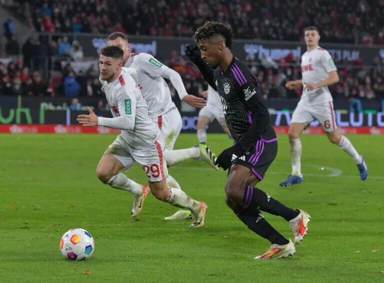 Kingsley Coman dribbles past a Koln defender