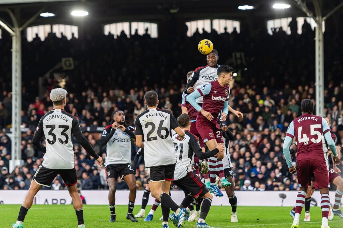 Fulham and West Ham players scramble in the box for a cross
