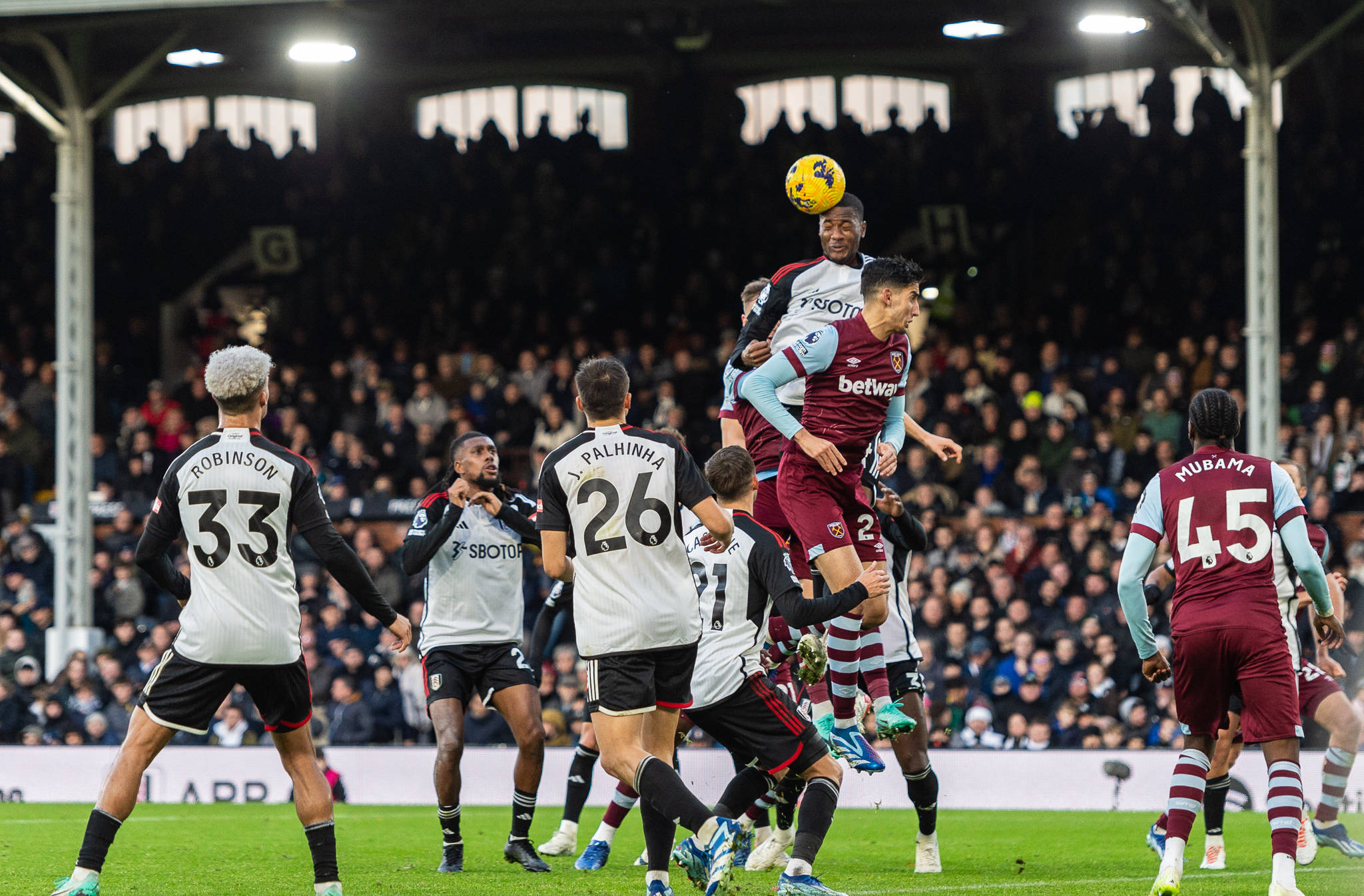 Fulham and West Ham players scramble in the box for a cross