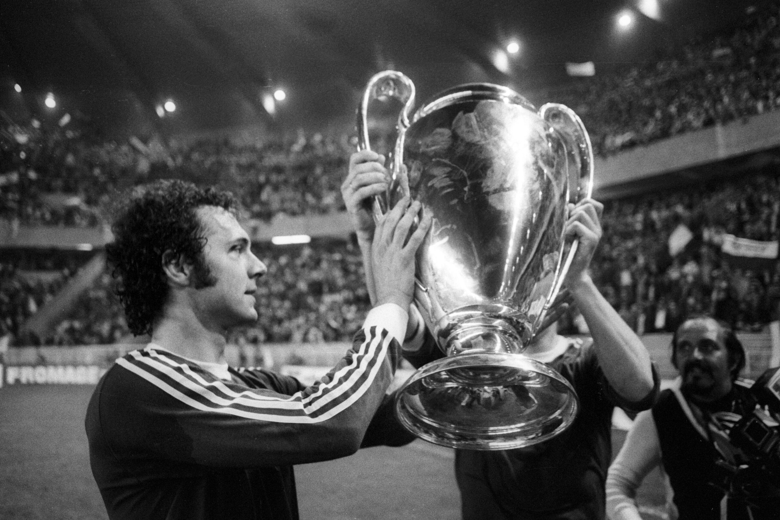 Franz Beckenbeaur being presented with the Uefa Champions League trophy