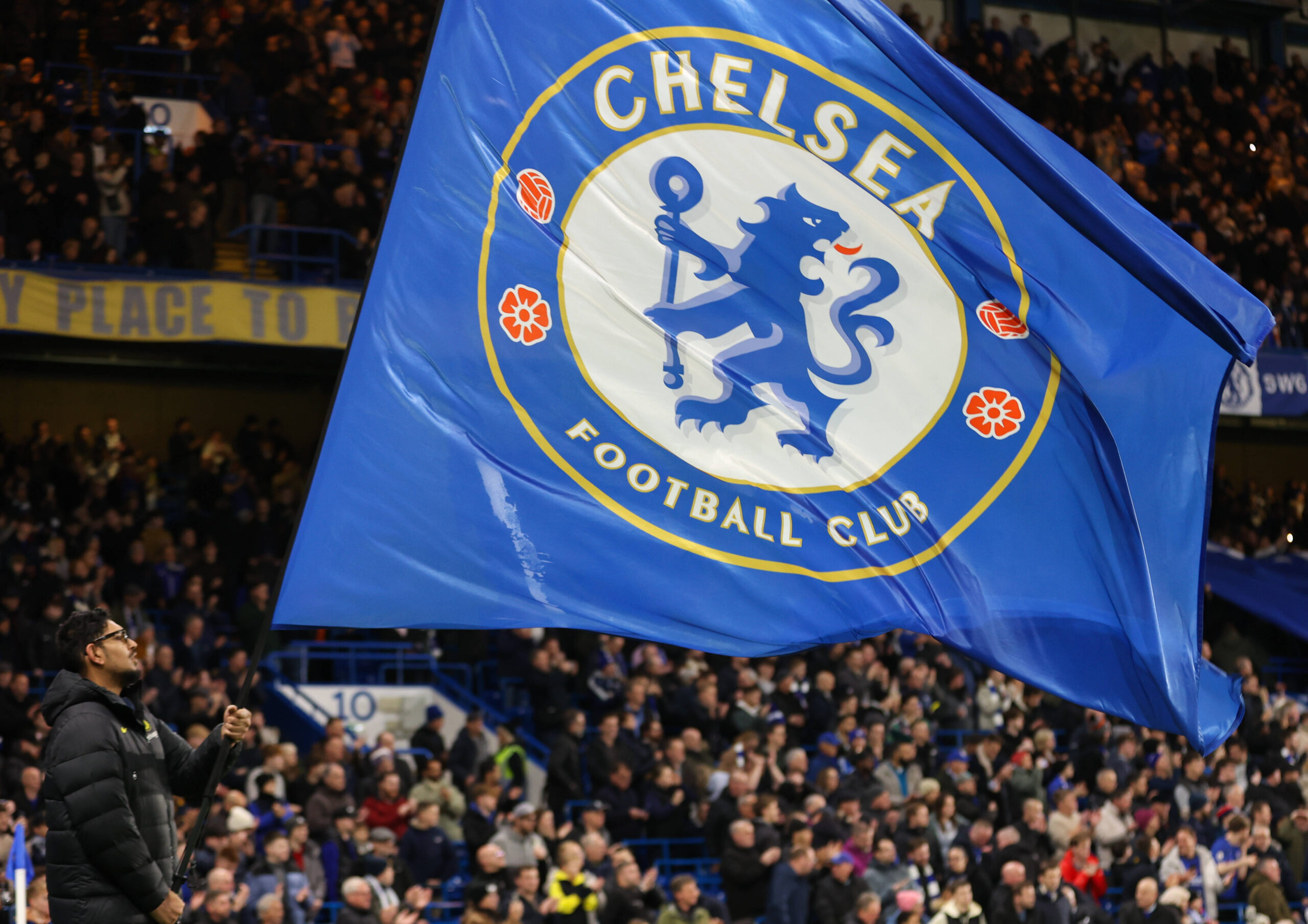 Chelsea flag being raised by fans at Stamford Bridge