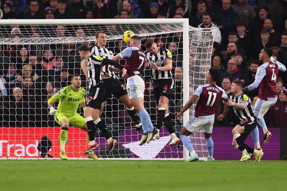 Aston Villa's John McGinn rises to head the ball despite competition from three Newcastle defenders