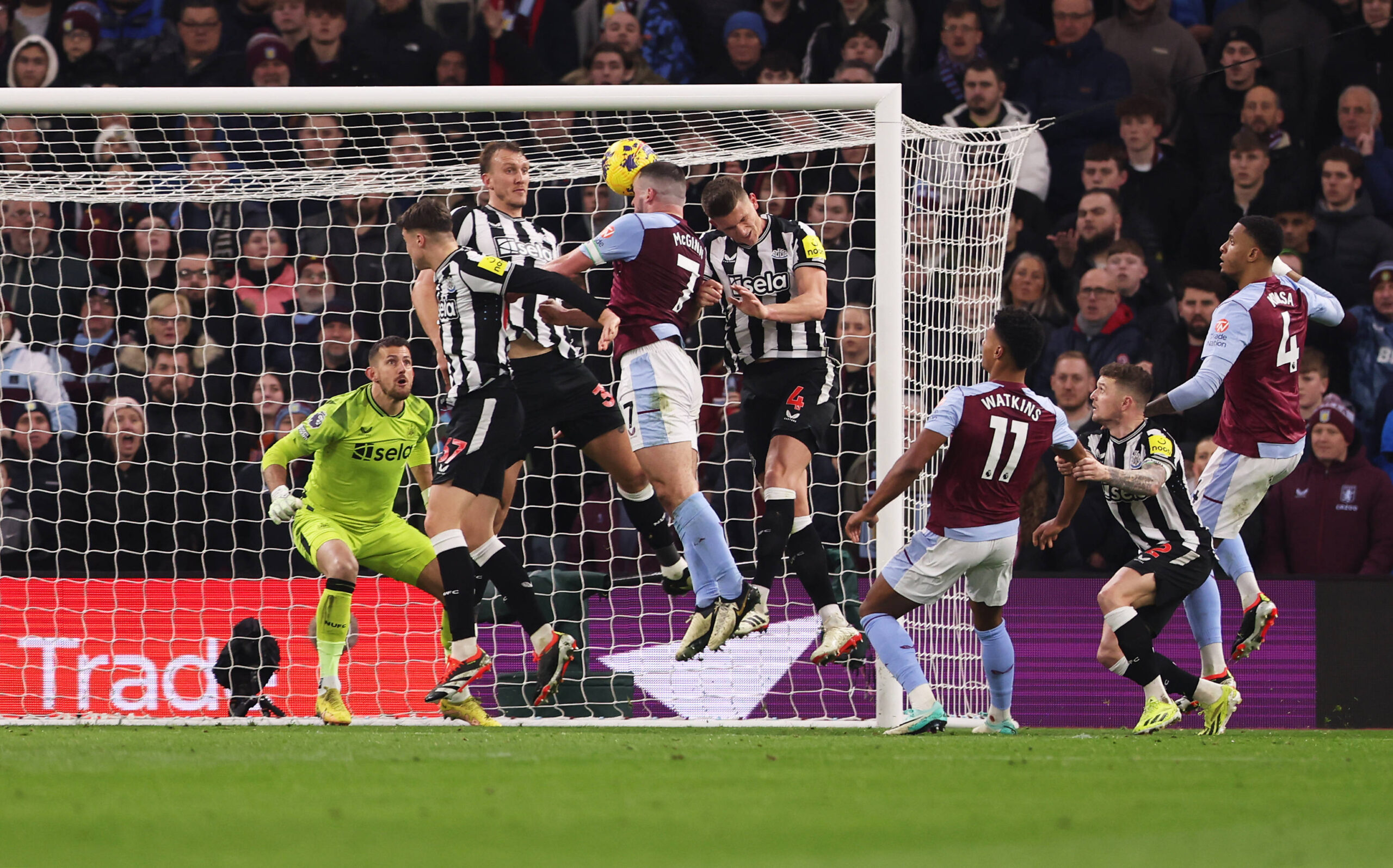 Aston Villa's John McGinn rises to head the ball despite competition from three Newcastle defenders