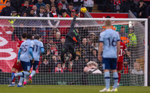 Liverpool goalkeeper Alisson saves a shot from Brentford player as teammates watch on