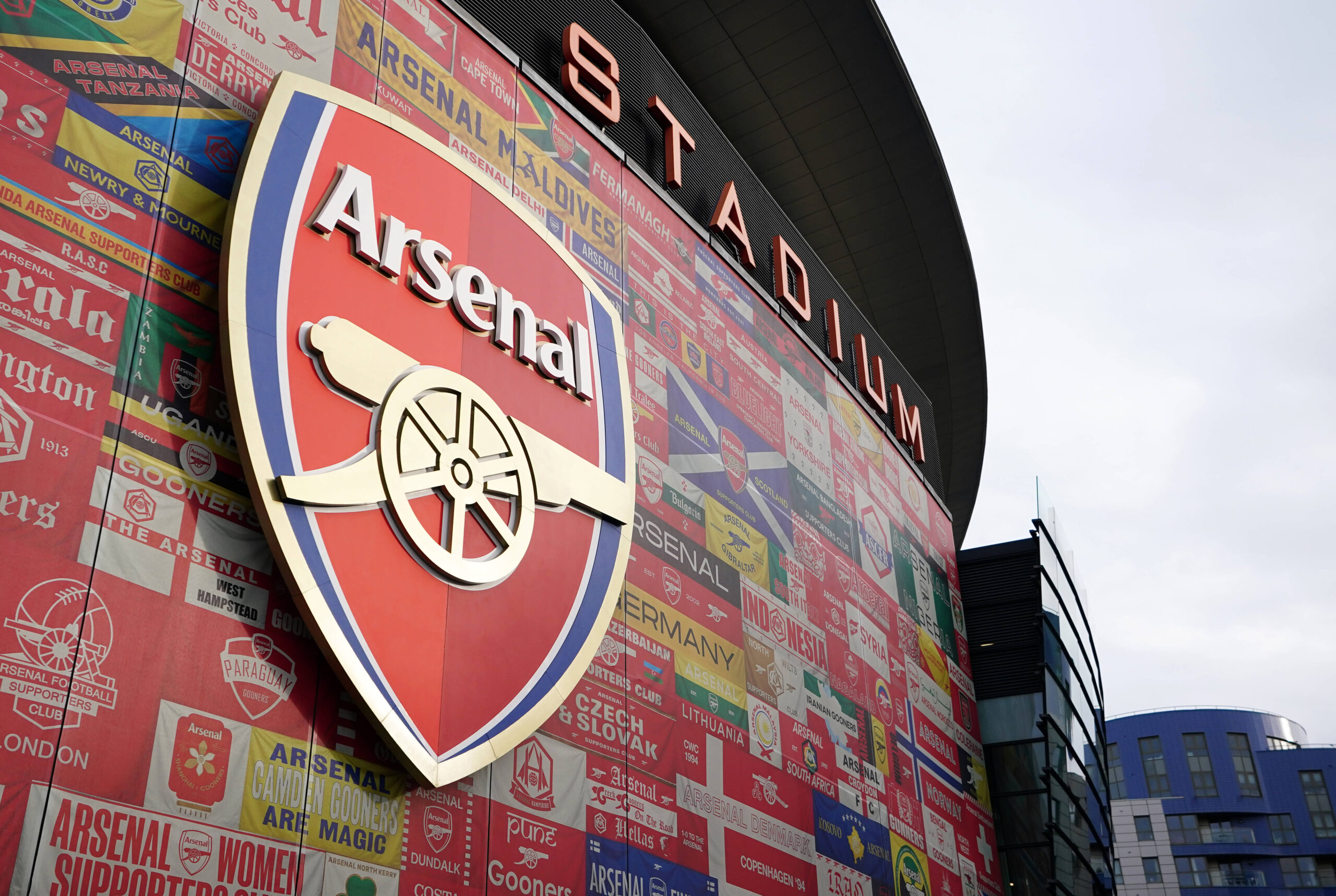 External view of Arsenal's Emirates stadium showing the club badge in front of an array of flags