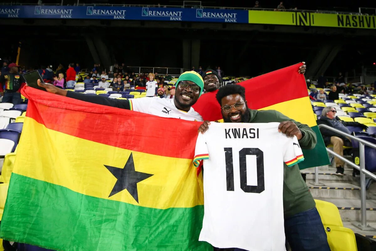 Ghana fans in the stands with a flag and player jerseys ahead of a Friendly