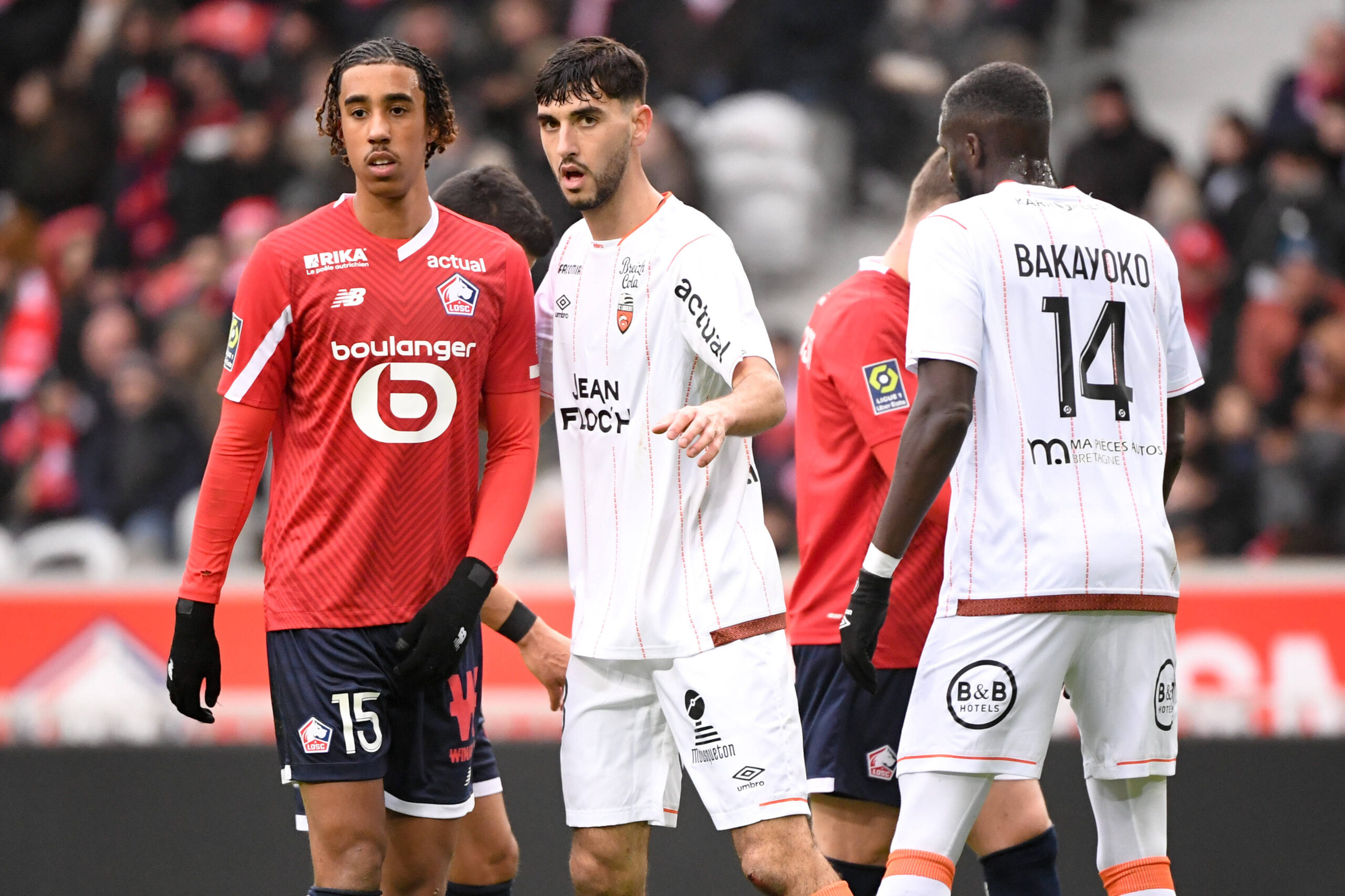 LOSC Lille defender Leny Yoro being marked by FC Lorient's Aurlien Pelon in a cruical Ligue 1 matchup