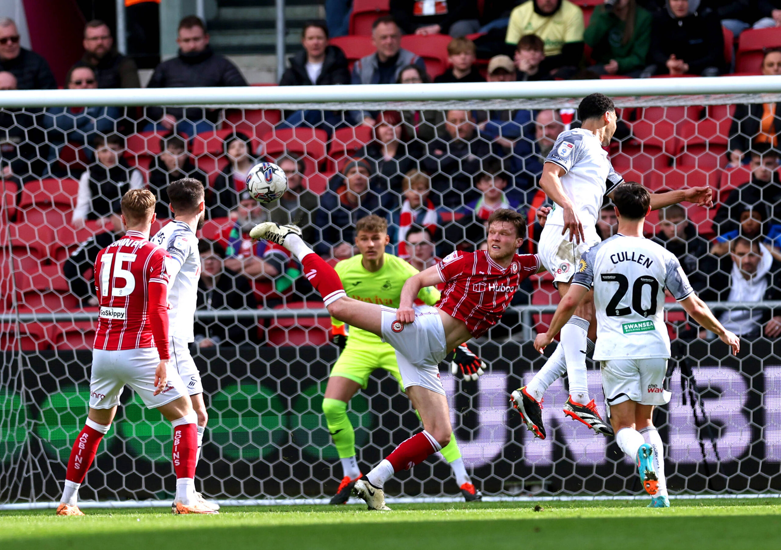 Bristol City defender stretches to block headed attempt by Swansea player