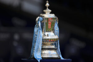 FA Cup trophy on display with Manchester City ribbons