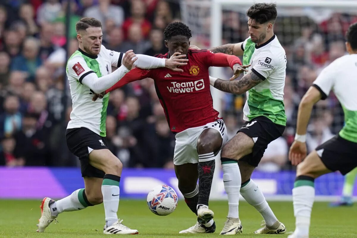 Liverpool's Alexis Mac Allister and Dominik Szoboszlai fight for the ball with Manchester United's Kobbie Mainoo.