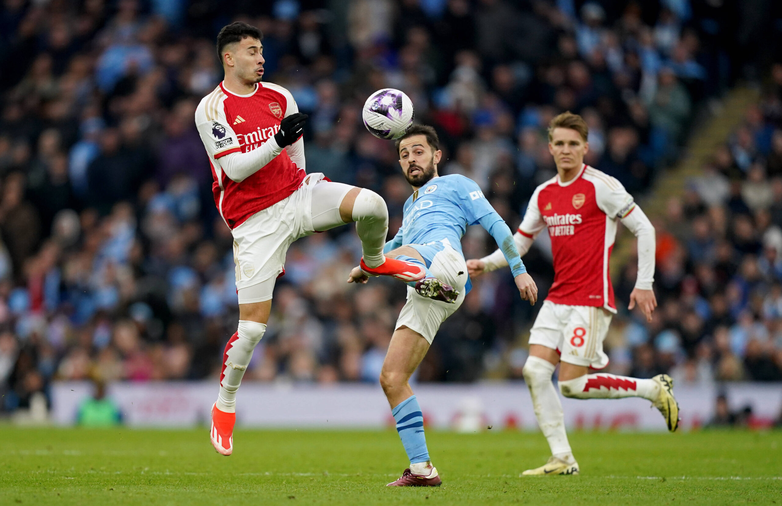 Arsenal winger Gabriel Martinelli fights Manchester City's Bernardo Silva for the ball.