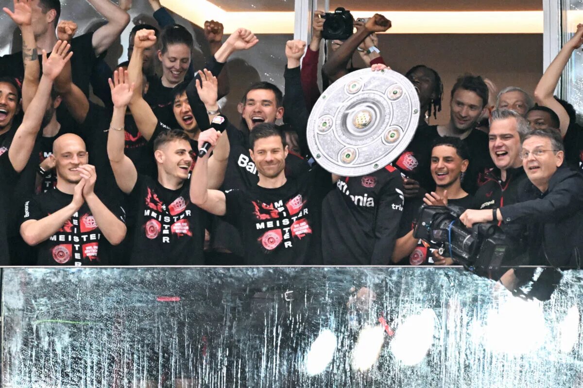 Bayer Leverkusen manager and players hold aloft the Bundesliga trophy