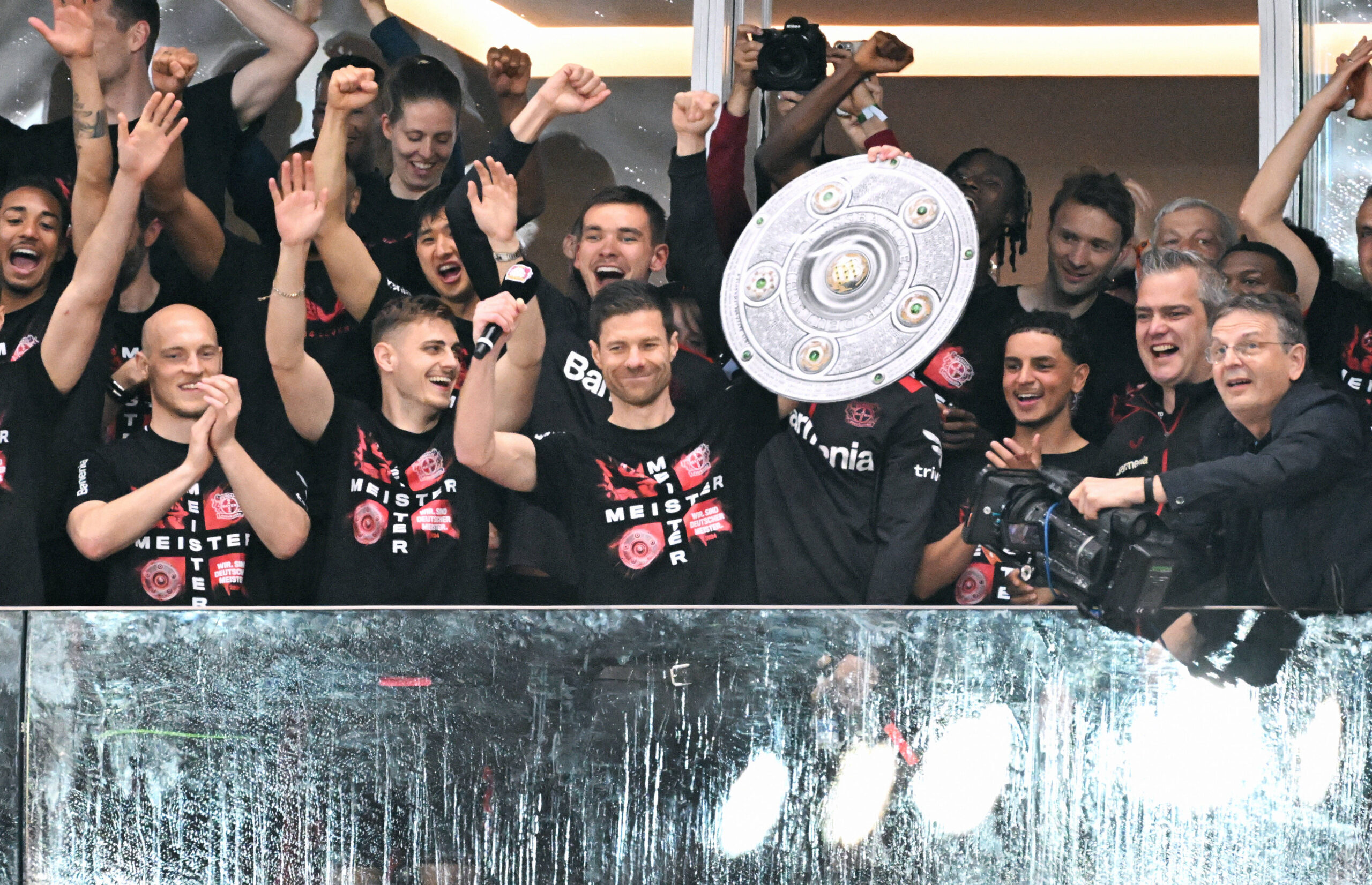 Bayer Leverkusen manager and players hold aloft the Bundesliga trophy