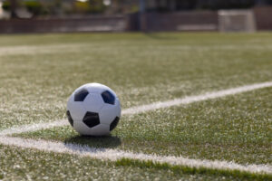 Image of a soccer ball at the edge of a field
