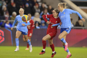 Esme Morgan competes with Liverpool player for a loose ball