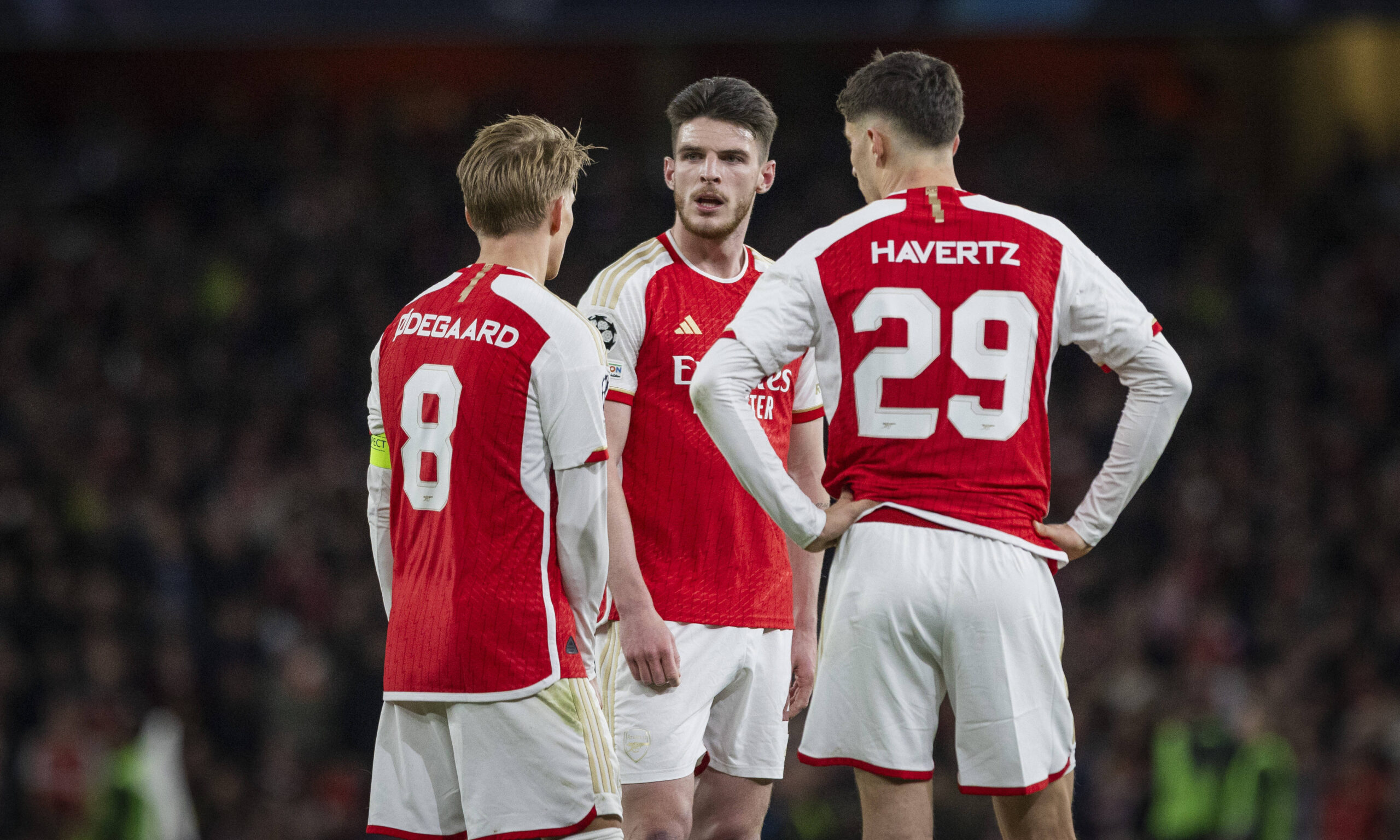 Arsenal's Martin Odegaard, Declan Rice, and Kai Havertz discuss before a set-piece situation.