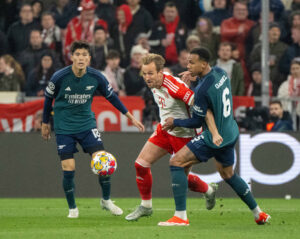 Arsenal's Takehiro Tomiyasu and Gabriel Magalhaes fight for the ball with Bayern Munich forward Harry Kane.