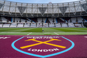 Image of the London Stadium showing the West Ham club badge on the ground of the entranceway