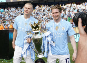 Erling Haaland and Kevin de Bruyne posing with the Premier League trophy.