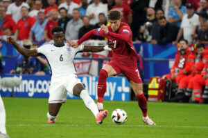 Marc Guehi vying for the ball with Serbia's Dusan Vlahovic in England's Euro 2024 opener.