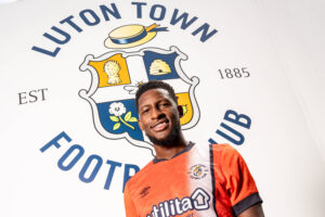 Shandon Baptiste pictured in front of the Luton Town logo