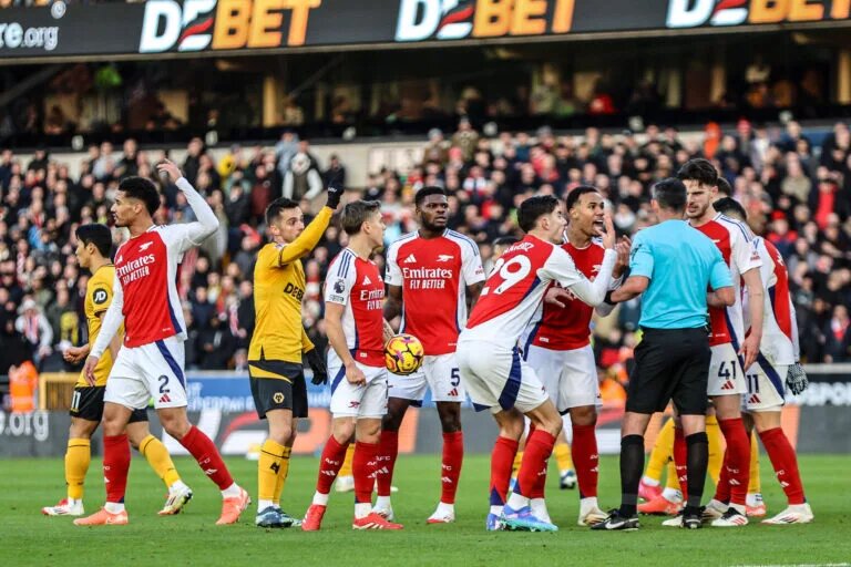 Arsenal players surround Michael Oliver after Myles Lewis-Skelly red card