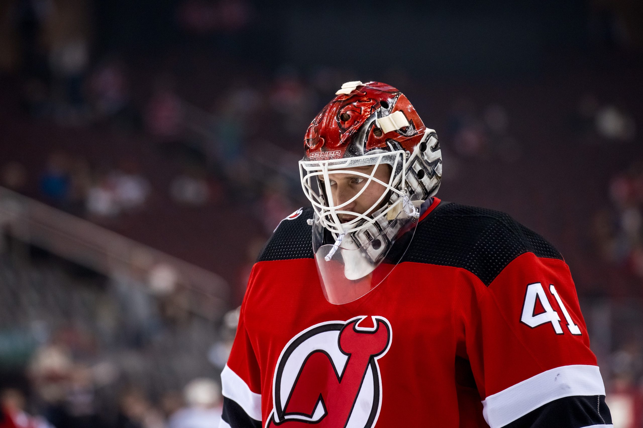 New Jersey Devils goaltender Akira Schmid, back, makes a glove