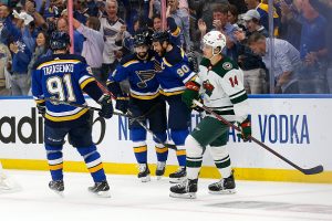 Joel Eriksson Ek #14 of the Minnesota Wild skates past Nick Leddy #4, Ryan OReilly #90, and Vladimir Tarasenko #91 of the St. Louis Blues as they celebrate Leedy's goal during the first period in Game Six of the First Round of the 2022 Stanley Cup Playoffs at the Enterprise Center on May 12, 2022 in St Louis, Missouri.