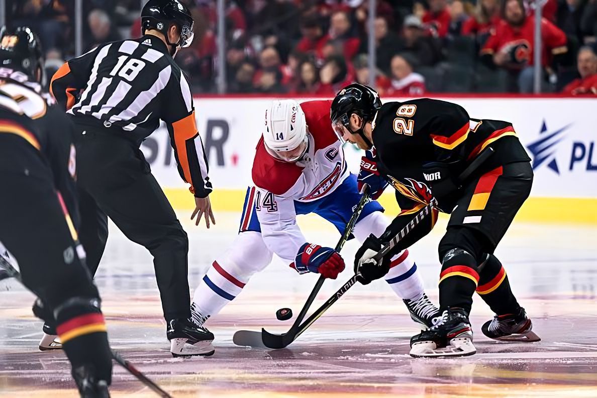 CALGARY, AB - DECEMBER 01: Montreal Canadiens Center Nick Suzuki (14) and Calgary Flames Center Elias Lindholm (28) take a face-off during the second period of an NHL game between the Calgary Flames and the Montreal Canadiens on December 1, 2022, at the Scotiabank Saddledome in Calgary, AB. (Photo by Brett Holmes/Icon Sportswire via NHL/Getty Images)