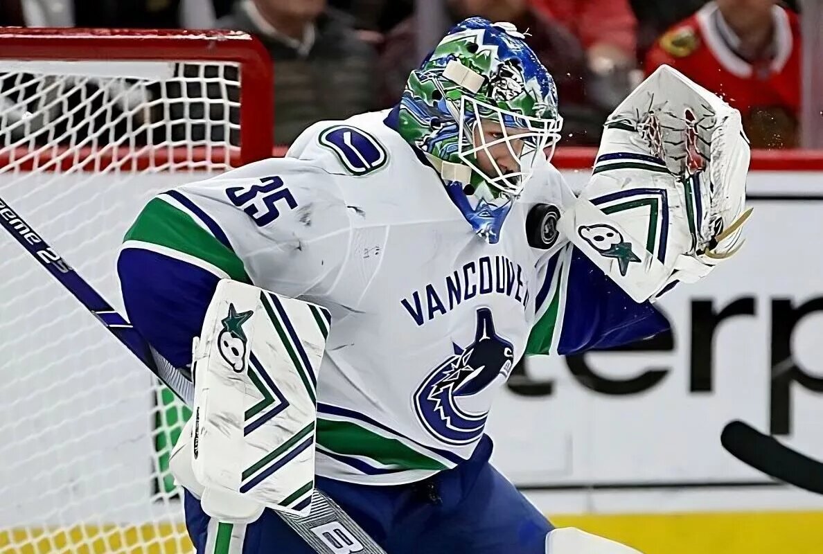 Vancouver Canucks goalie Thatcher Demko makes a save while wearing his white #35 away jersey.