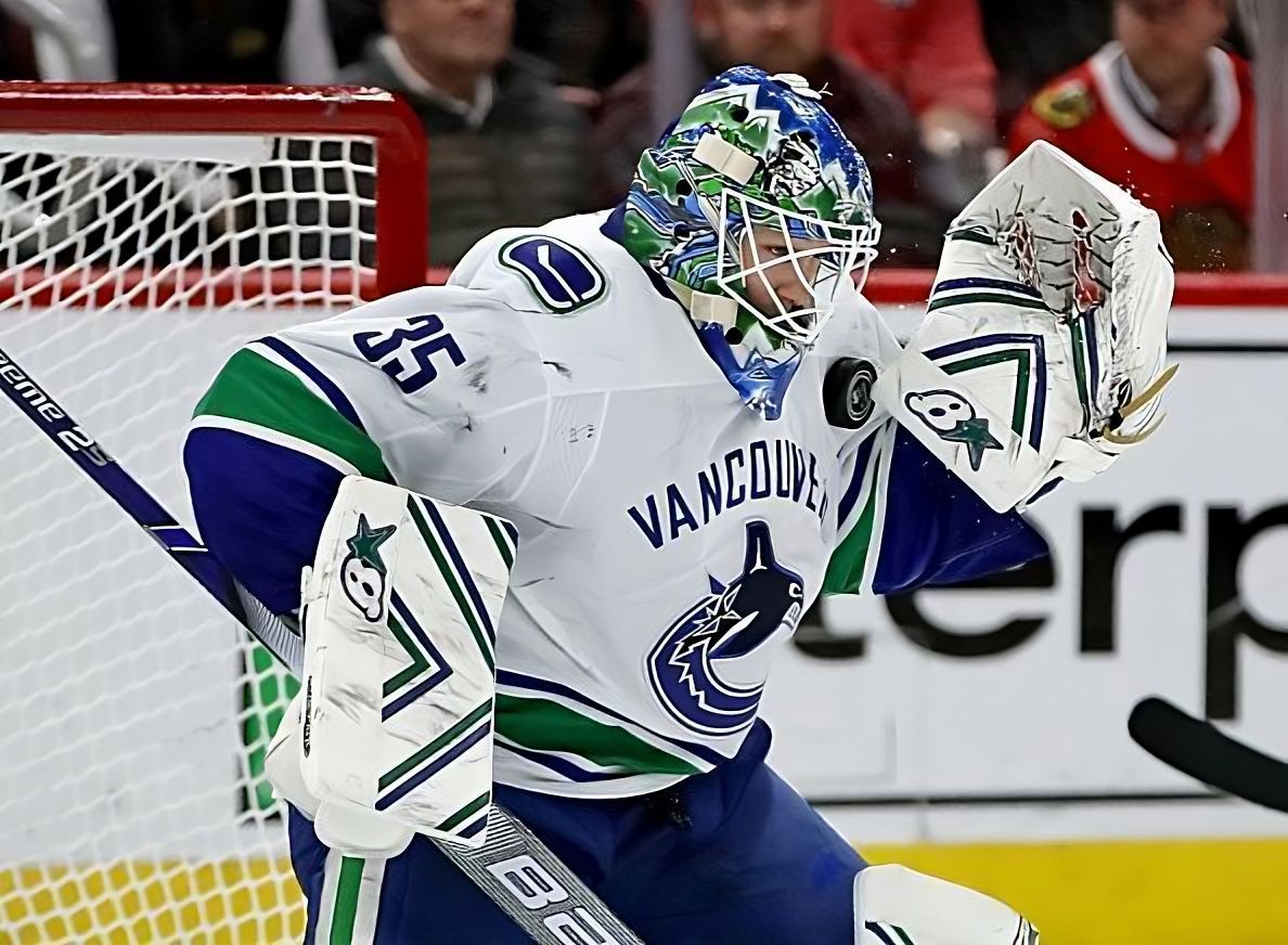 Vancouver Canucks goalie Thatcher Demko makes a save while wearing his white #35 away jersey.
