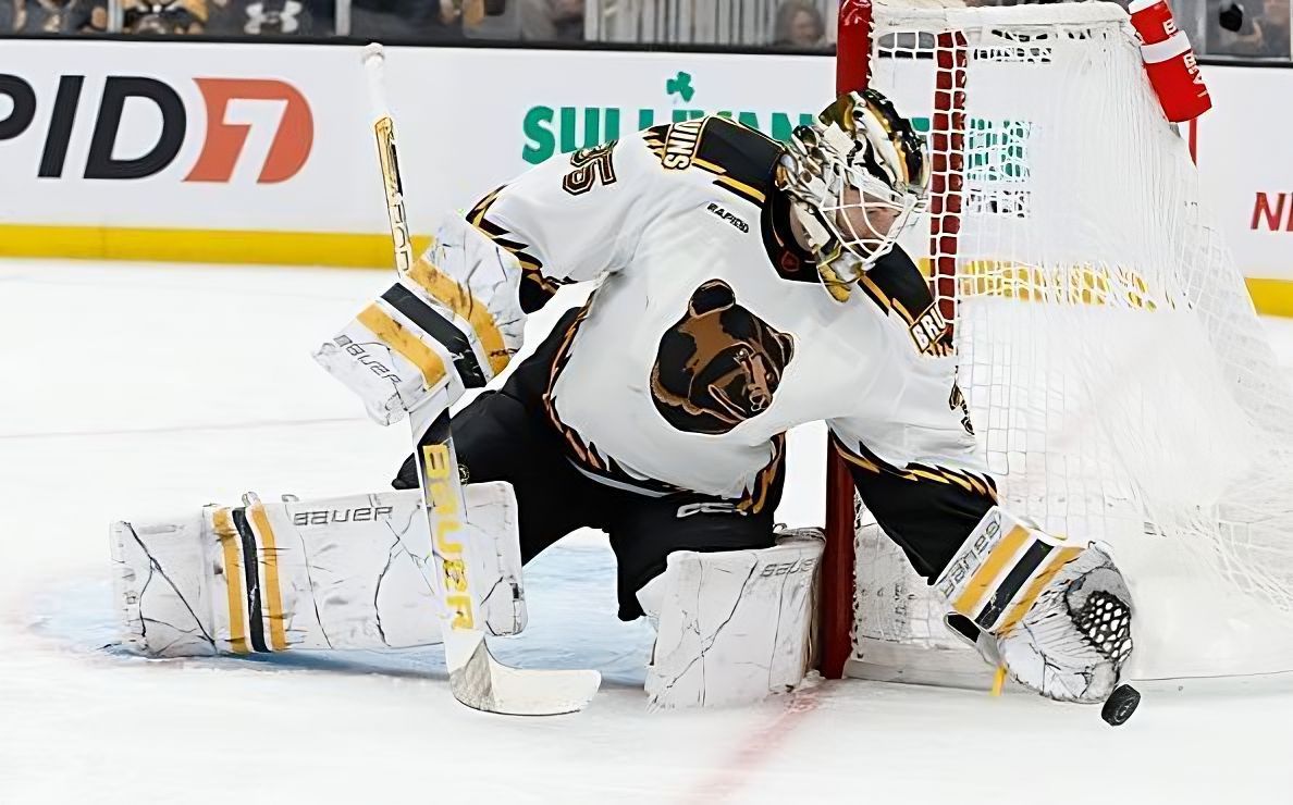 Boston Bruins goalie Linus Ullmark making a save, wearing his white Reverse Retro jersey.