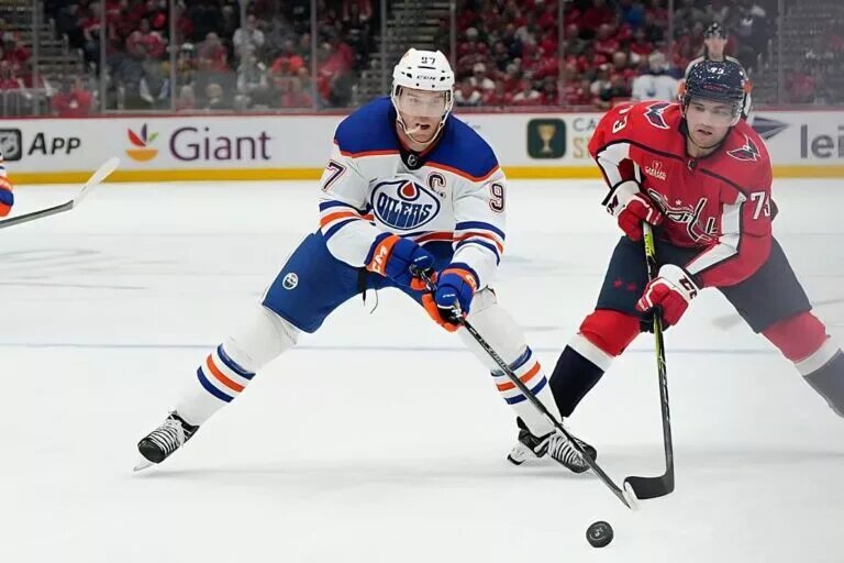 WASHINGTON, DC - NOVEMBER 07: Connor McDavid #97 of the Edmonton Oilers reaches for the puck against Conor Sheary #73 of the Washington Capitals during the third period at Capital One Arena on November 07, 2022 in Washington, DC. This is McDavid's 500th career game. (Photo by Jess Rapfogel/NHL//Getty Images)
