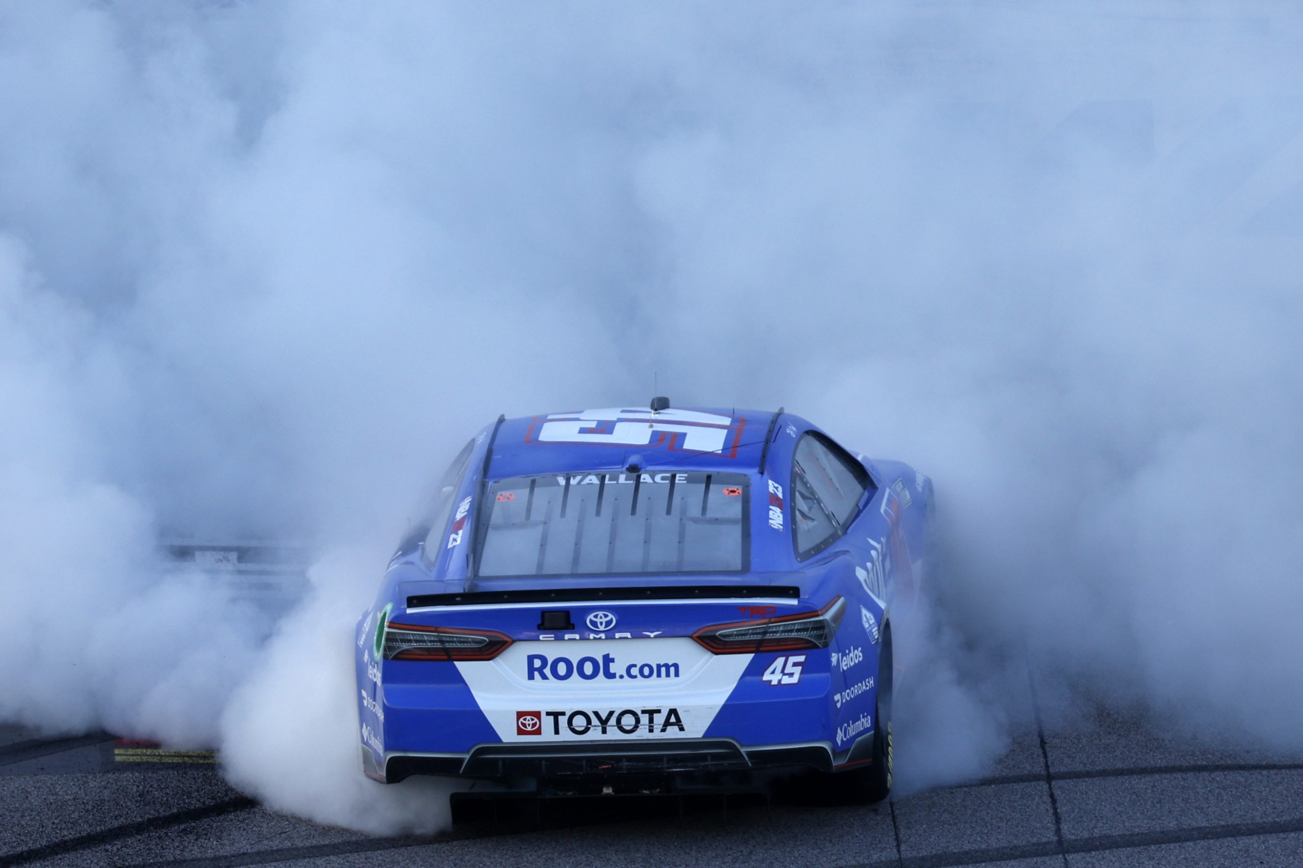 Bubba Wallace performs a burnout after his win at Kansas Speedway