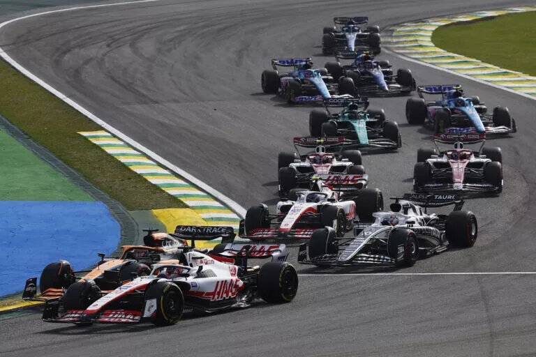 AUTóDROMO JOSé CARLOS PACE, BRAZIL - NOVEMBER 13: Sebastian Vettel, Aston Martin AMR22, leads Kevin Magnussen, Haas VF-22, Daniel Ricciardo, McLaren MCL36, Pierre Gasly, AlphaTauri AT03, Mick Schumacher, Haas VF-22, and the remainder of the field at the start during the São Paulo GP at Autódromo José Carlos Pace on Sunday November 13, 2022 in Sao Paulo, Brazil. (Photo by Sam Bloxham / LAT Images)