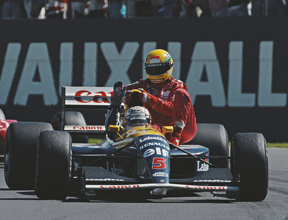 F1 - Nigel Mansell driving the #5 Canon Williams Renault Williams FW14 Renault V10 gives Ayrton Senna a ride back to the pits after he had run out of fuel during the British Grand Prix on 14th July 1991 at the Silverstone Circuit in Towcester, Great Britain. (Photo by Pascal Rondeau/Allsport/Getty Images)