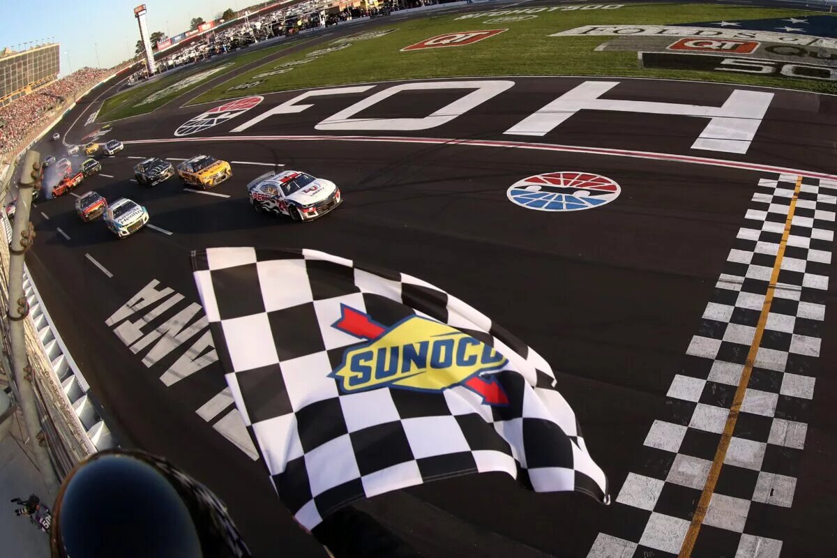 HAMPTON, GEORGIA - MARCH 20: William Byron, driver of the #24 Liberty University Chevrolet, takes the checkered flag to win the NASCAR Cup Series Folds of Honor QuikTrip 500 at Atlanta Motor Speedway on March 20, 2022 in Hampton, Georgia. (Photo by Mike Mulholland/Getty Images)