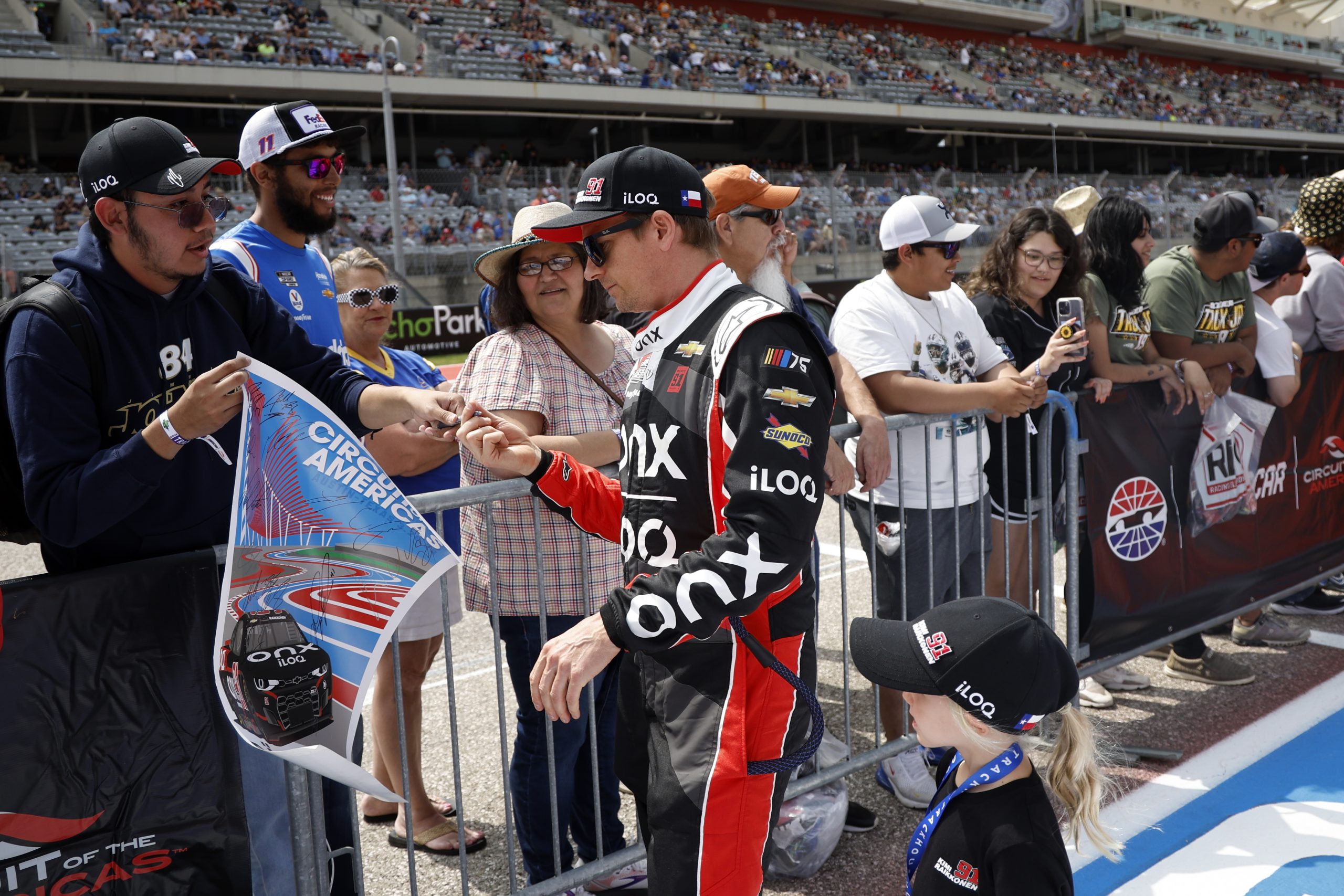 AUSTIN, TEXAS - MARCH 26: Kimi Raikkonen, driver of the #91 Onx Homes/iLOQ Chevrolet, signs an autograph for a NASCAR fan prior to the NASCAR Cup Series EchoPark Automotive Grand Prix at Circuit of The Americas on March 26, 2023 in Austin, Texas. (Photo by Chris Graythen/Getty Images)