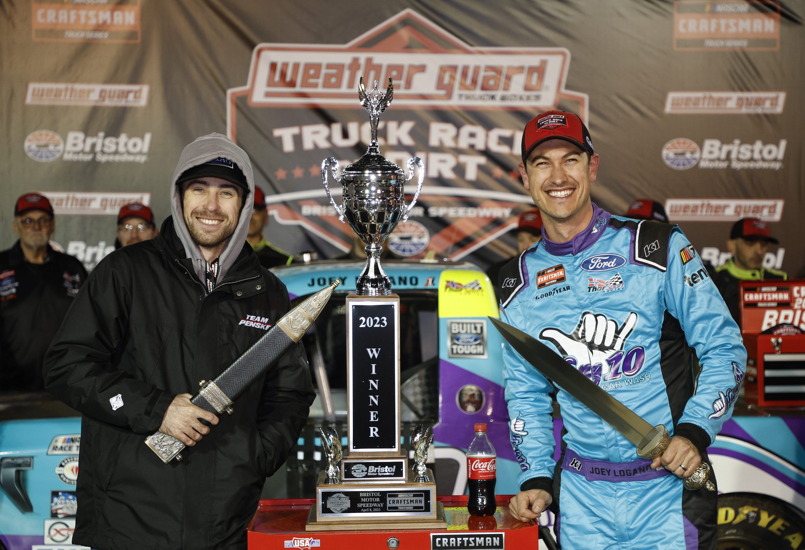Credit: BRISTOL, TENNESSEE - APRIL 08: Joey Logano, driver of the #66 Hang 10 Car Wash Ford, and his spotter, NASCAR Cup Series driver Ryan Blaney, celebrate in victory lane after winning the NASCAR Craftsman Truck Series Weather Guard Truck Race on Dirt at Bristol Motor Speedway on April 08, 2023 in Bristol, Tennessee. (Photo by Jared C. Tilton/Getty Images)
