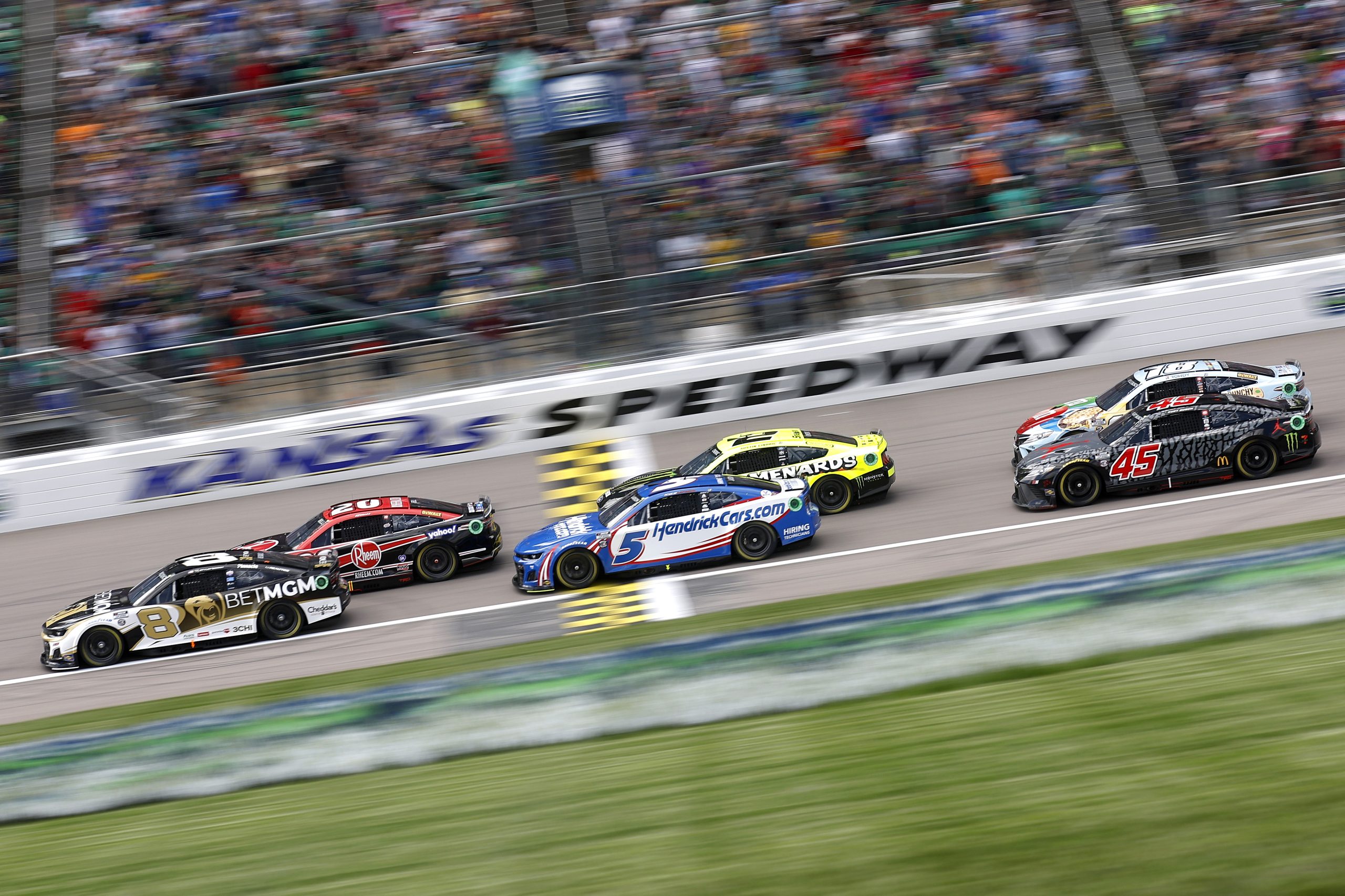 Credit: KANSAS CITY, KANSAS - MAY 15: Tyler Reddick, driver of the #8 BetMGM Chevrolet, Christopher Bell, driver of the #20 Rheem Toyota, Kyle Larson, driver of the #5 HendrickCars.com Chevrolet, Austin Cindric, driver of the #2 Menards/Monster Ford, Kurt Busch, driver of the #45 Jordan Brand Toyota, and Kyle Busch, driver of the #18 M&M's Crunchy Cookie Toyota, race during the NASCAR Cup Series AdventHealth 400 at Kansas Speedway on May 15, 2022 in Kansas City, Kansas. (Photo by Chris Graythen/Getty Images)