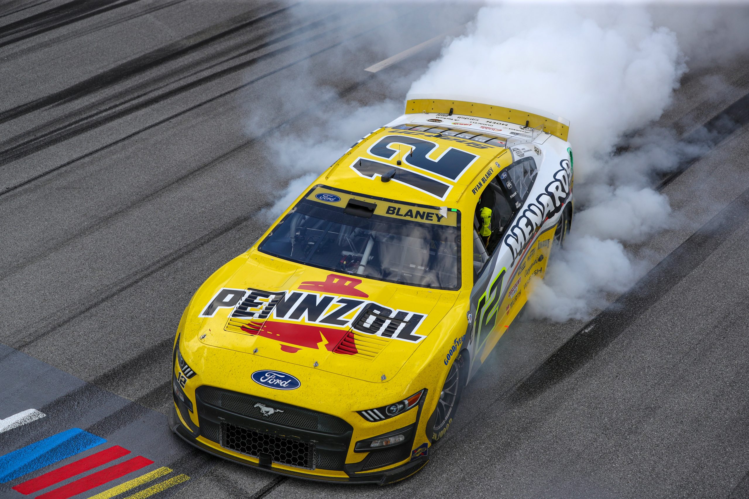 Ryan Blaney, driver of the #12 Menards/Pennzoil Ford, celebrates with a burnout after winning the NASCAR Cup Series YellaWood 500 at Talladega Superspeedway on October 01, 2023 in Talladega, Alabama.